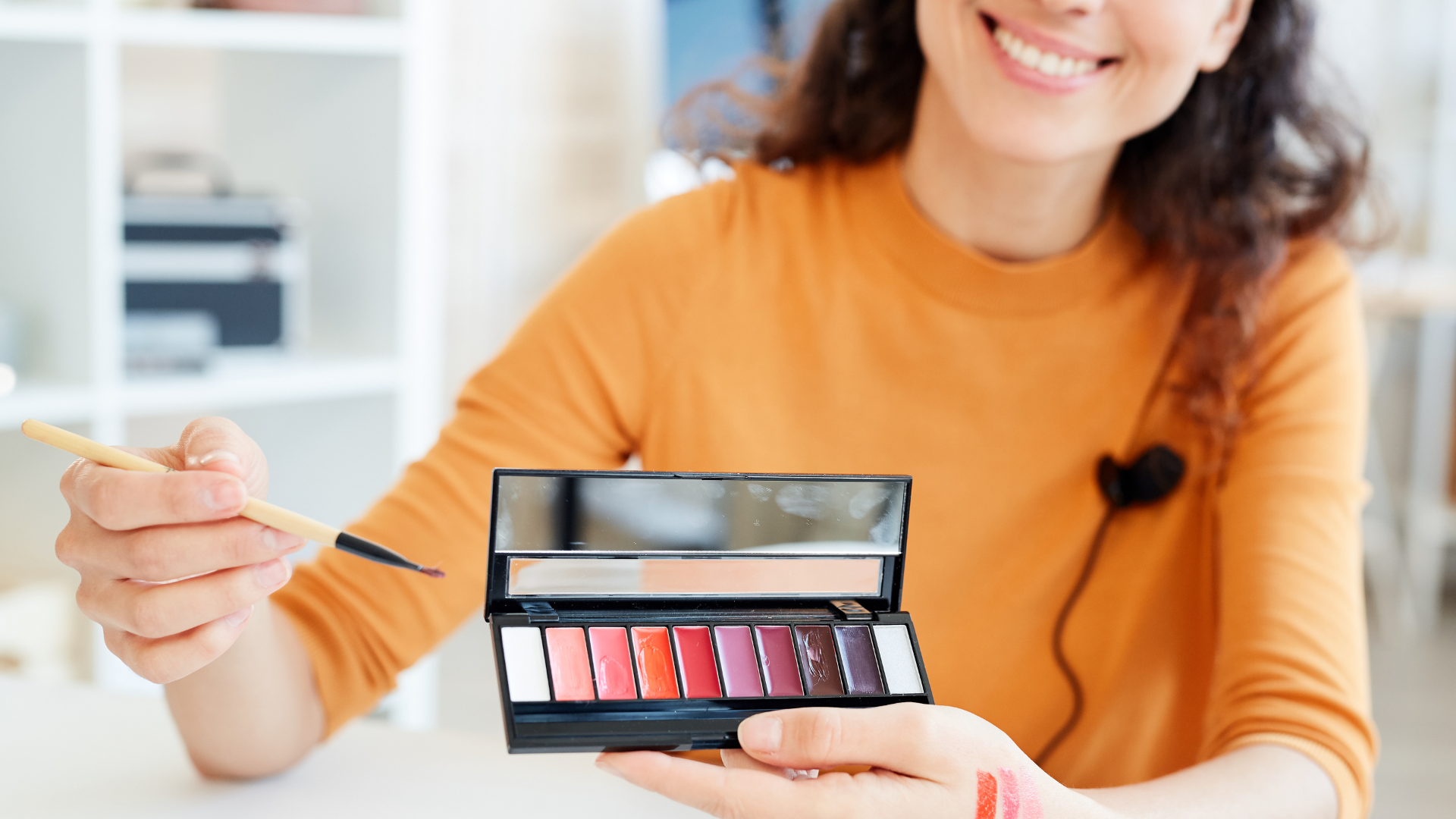 Make Up Artist con palette di rossetti rosa e rossi